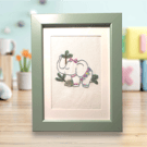 Hand embroidered framed picture of a cute elephant dressed in pastels, palm tree
