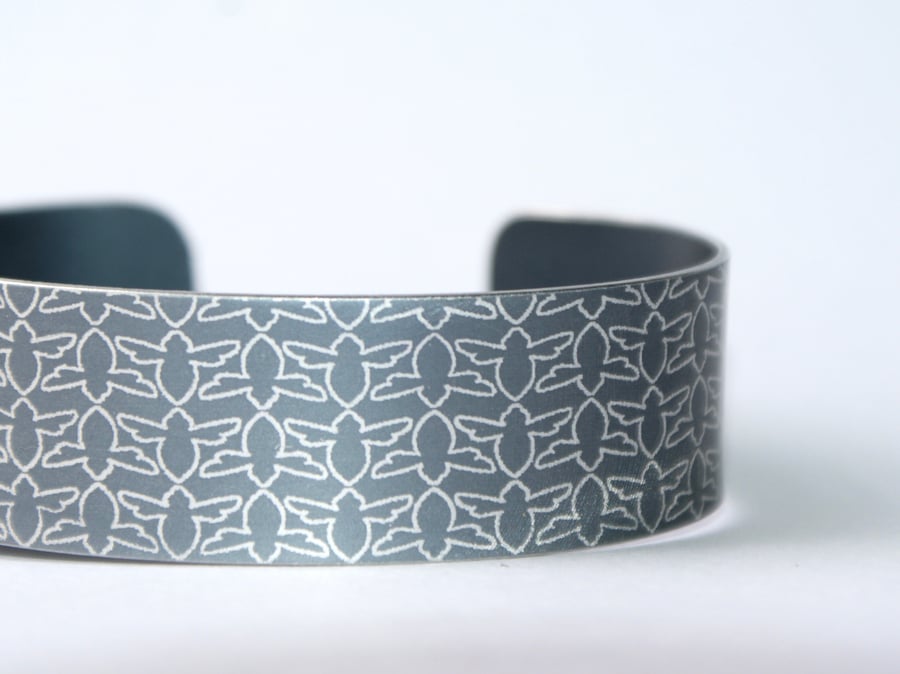 Grey aluminium cuff with bee pattern