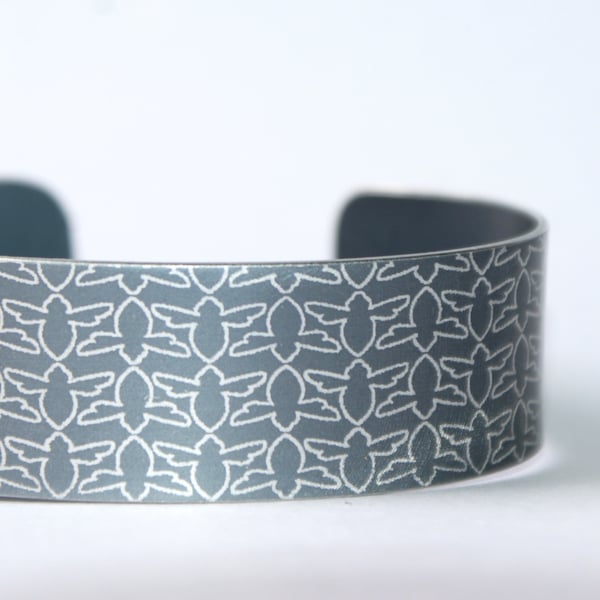 Grey aluminium cuff with bee pattern