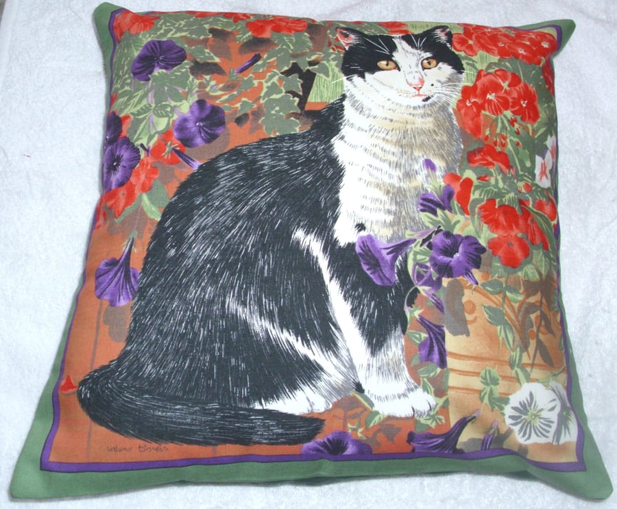 A lovely black and white cat in the garden cushion