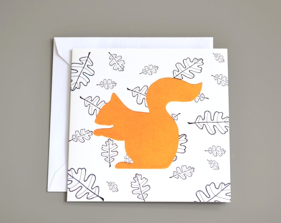 Squirrel in front of black and white leaf pattern blank card.