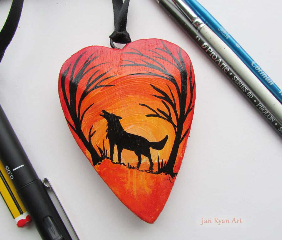 Wolf silhouette by sunrise, orange hanging heart