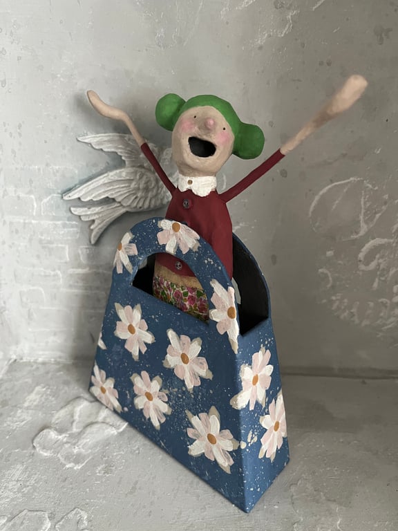 Paper mache art doll in a cardboard handbag