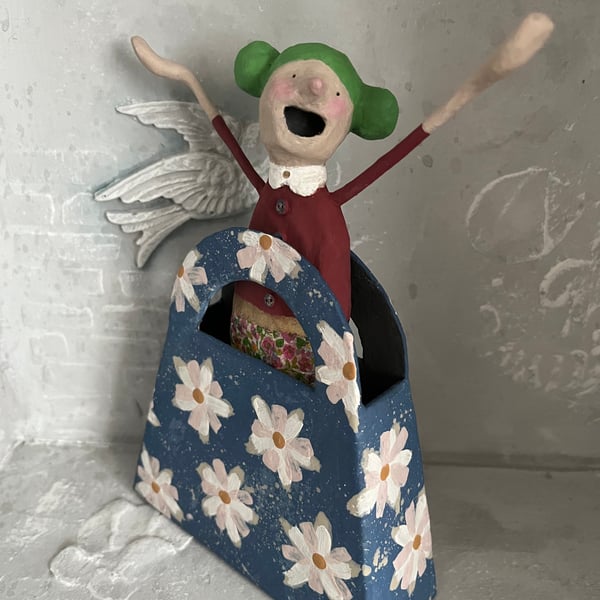Paper mache art doll in a cardboard handbag