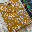 Fabric book sleeve with pocket for paperback books. Padded and fully lined.