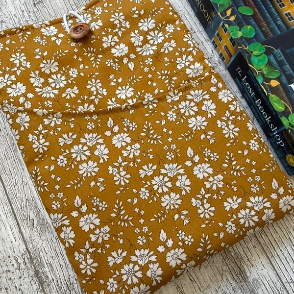 Fabric book sleeve with pocket for paperback books. Padded and fully lined.