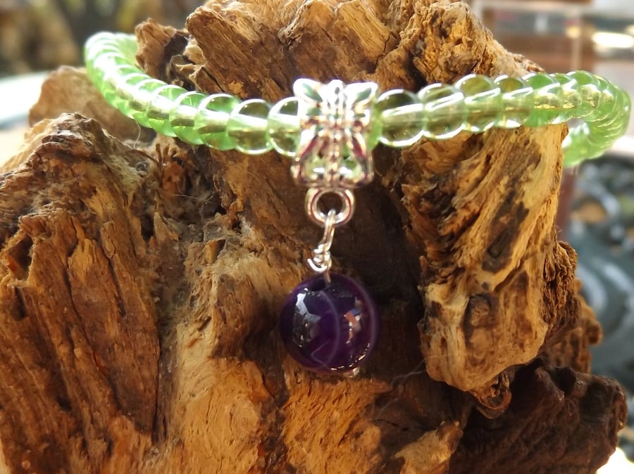 Green glass beaded stretch bracelet with purple bead charm