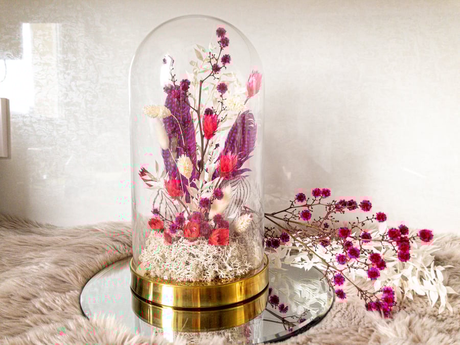 Dried flower arrangement in glass cloche dome