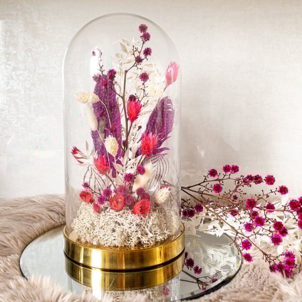 Dried flower arrangement in glass cloche dome