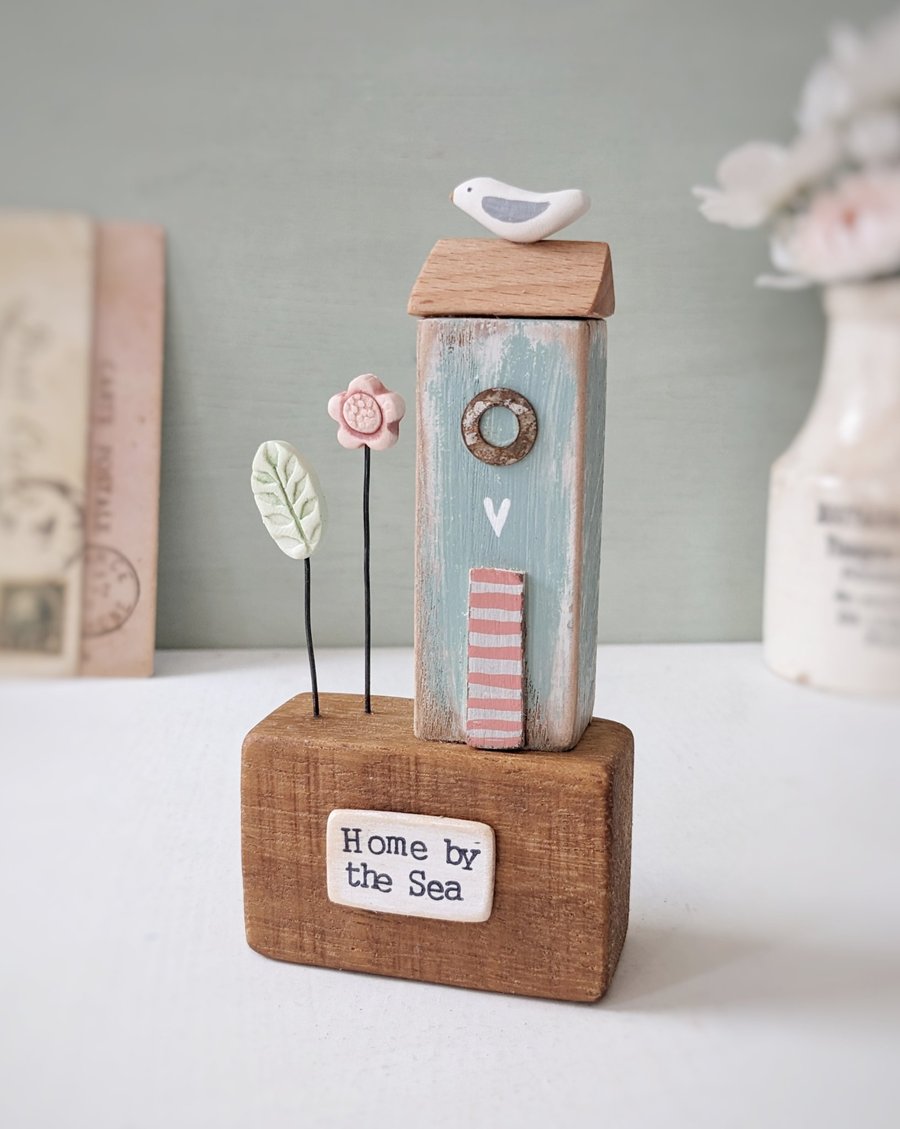 Image of Tall Wooden Sea Hut with Clay Flower and Seagull 'Home by the Sea'