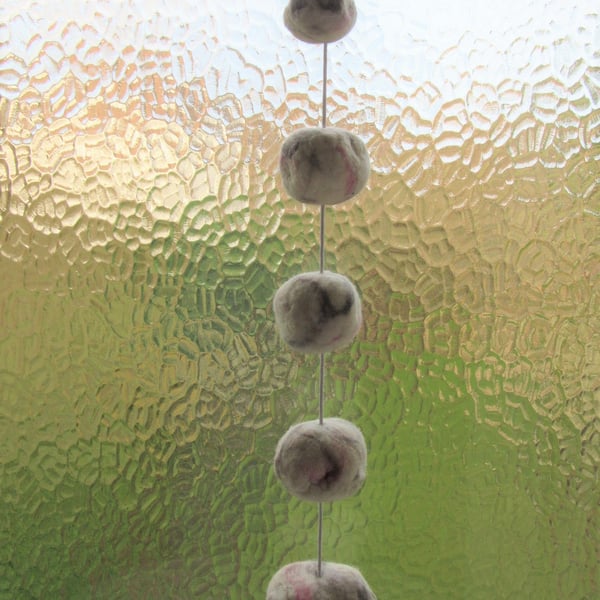 Hanging window decoration.  Hand felted soft white pebbles and stones on cord