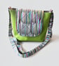 Light green messenger bag with bold colour accent.
