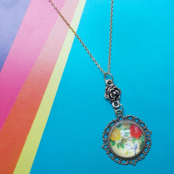 A Japanese Image of Flowers and Birds in a Glass Cabochon Pendant