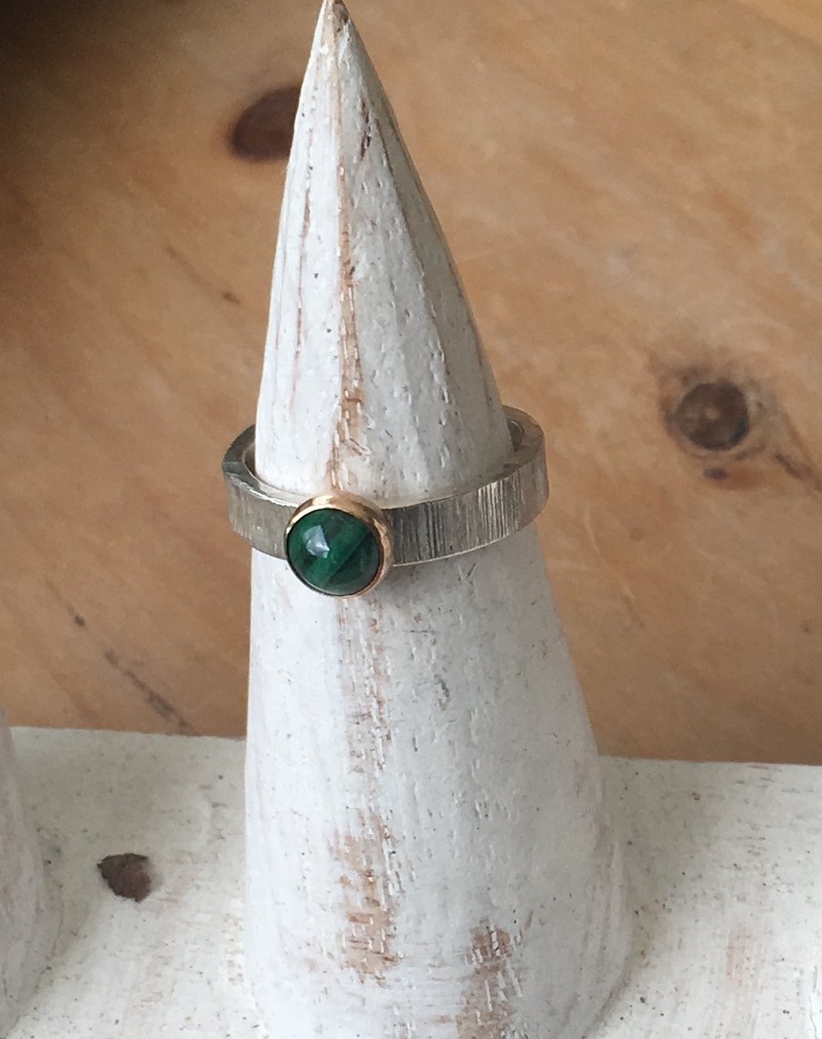 6mm Malachite set in 9 carat gold on textured wide silver band. Size L.5