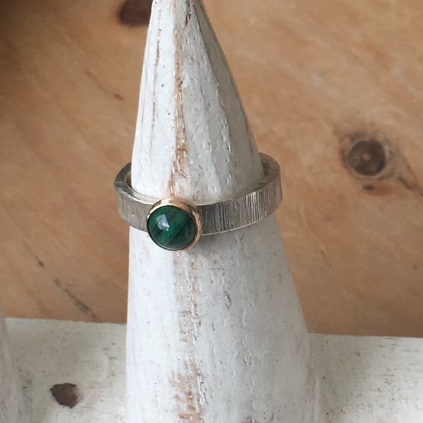6mm Malachite set in 9 carat gold on textured wide silver band. Size L.5