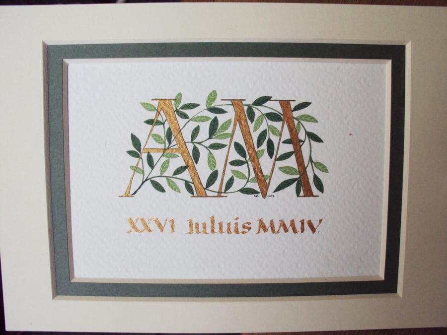 Wedding initials in gold with dark green leaves