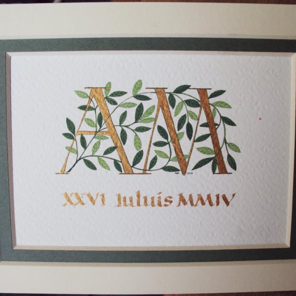 Wedding initials in gold with dark green leaves