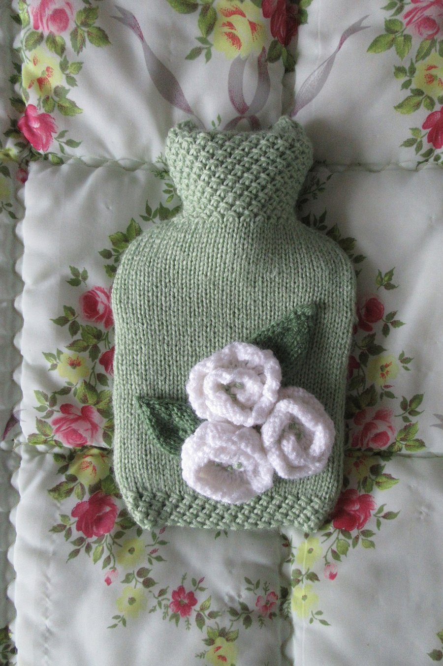 Hand knitted soft green hot water bottle cover with cream roses