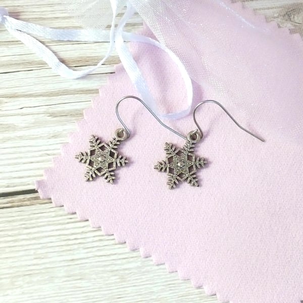 Small silver metal snowflake earrings on steel wires, Christmas jewellery