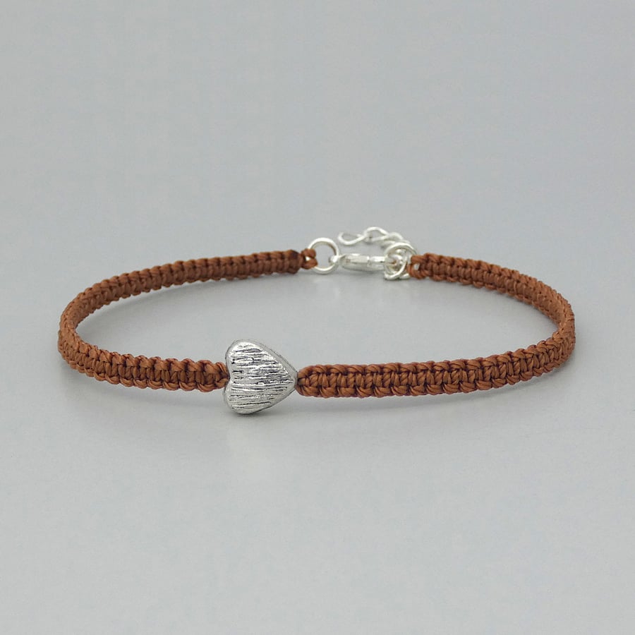 Brown 7" macramé bracelet with silver plated heart charm and 1” extender chain.