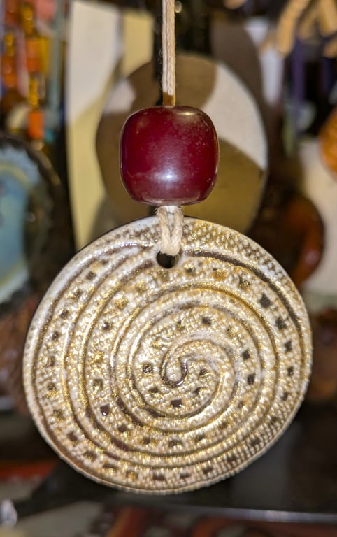 Stoneware necklace: a round ceramic white glaze spiral with Victorian amber bead