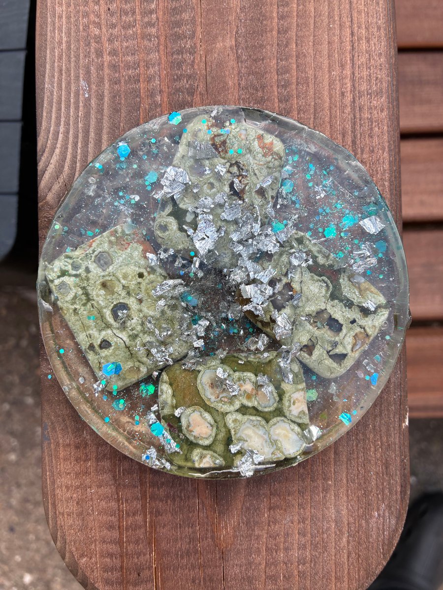 Large round resin coaster with shavings of silver foil and green agate flat bead