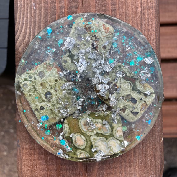 Large round resin coaster with shavings of silver foil and green agate flat bead