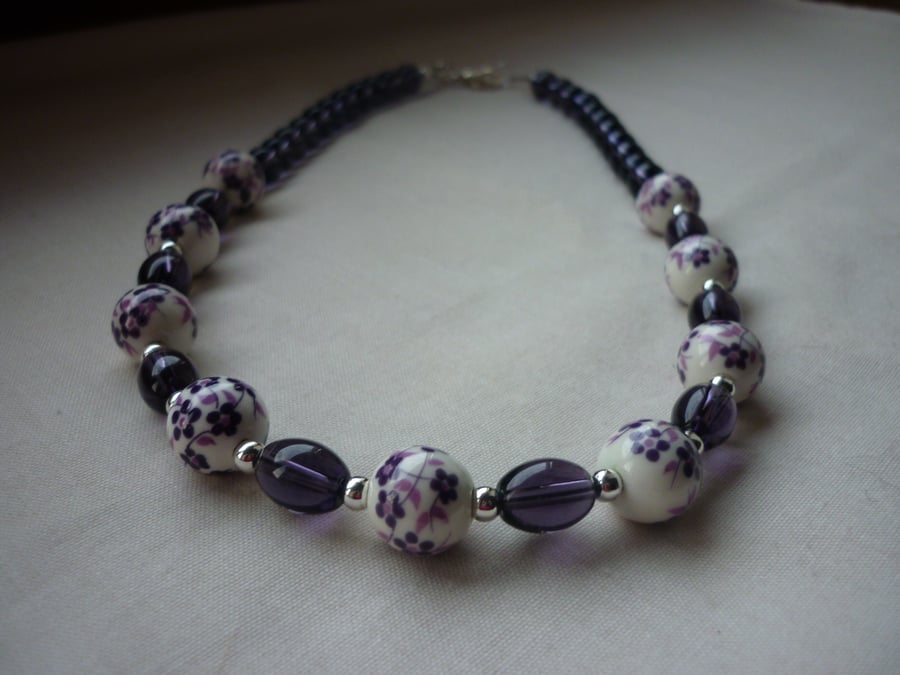 PURPLE, WHITE AND SILVER FLORAL PORCELAIN NECKLACE.  1044