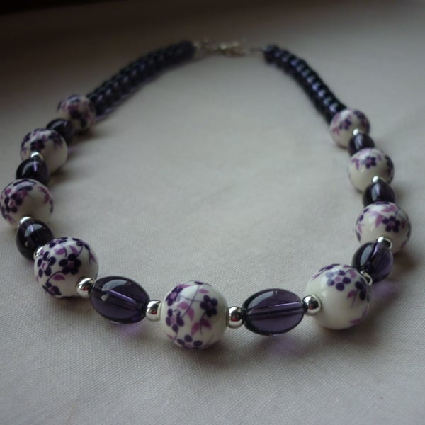 PURPLE, WHITE AND SILVER FLORAL PORCELAIN NECKLACE.  1044