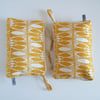 Toiletries or make up bag in bold hand printed yellow fabric.