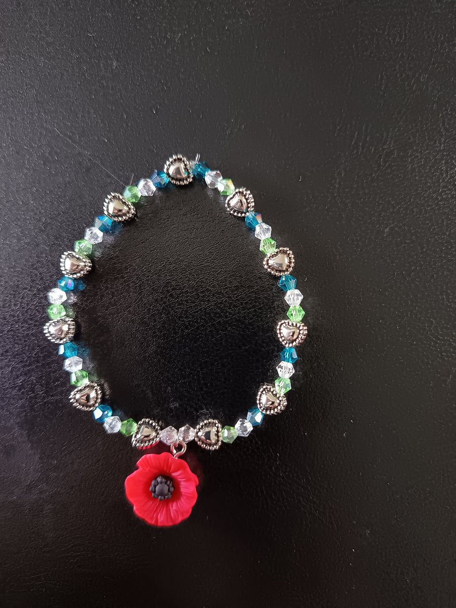 Elasticated poppy charm bracelet with silver and glass beads 