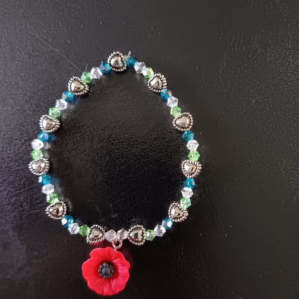 Elasticated poppy charm bracelet with silver and glass beads 