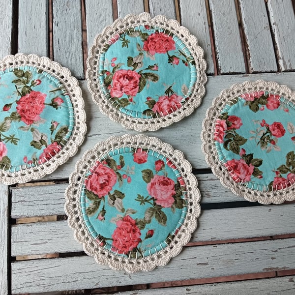 Set of four handmade floral coasters with crochet edge.