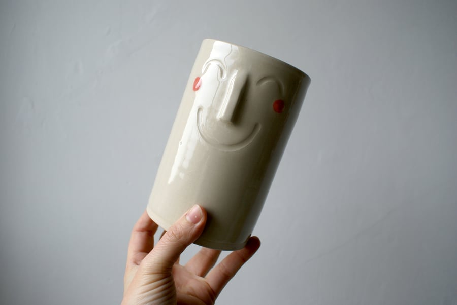 Handcrafted small stoneware vase with blushing smiling face in transparent