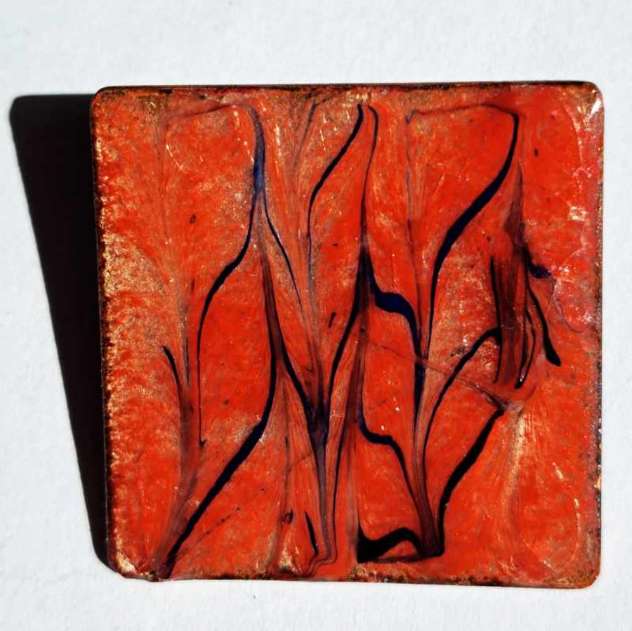 brooch - square: scrolled black and dark blue on red over clear enamel