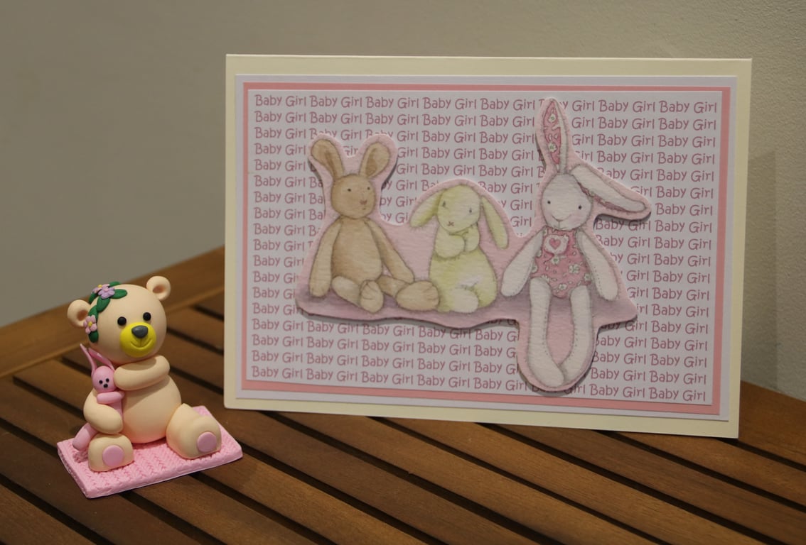 New baby Girl card, rabbit toys image on a text background