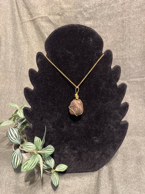 Beautiful wire wrapped brown pebble pendant on gold coloured chain. 