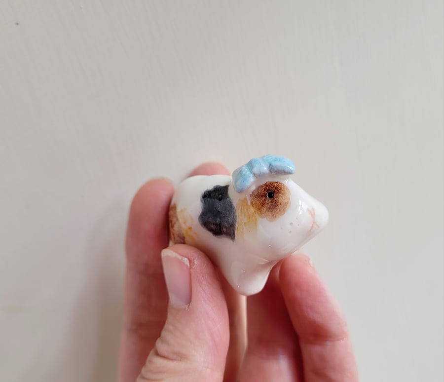 Ceramic guinea pig figure with blue bow. Handmade piggie figurine