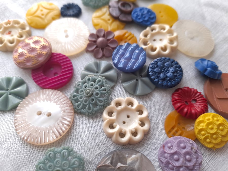 Old ornate buttons in a variety of shapes, sizes and colours