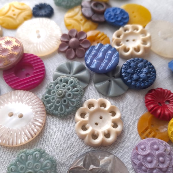 Old ornate buttons in a variety of shapes, sizes and colours