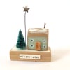 Little wooden house with Christmas tree and star