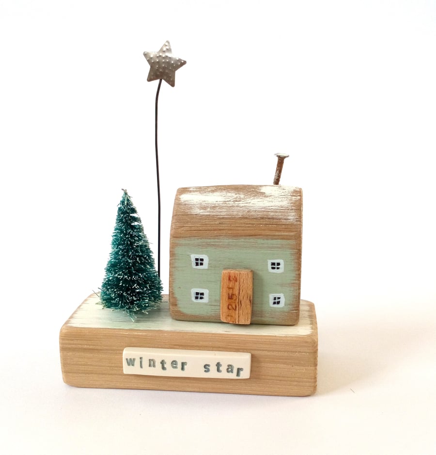 Little wooden house with Christmas tree and star