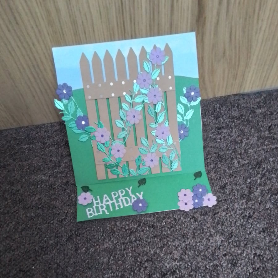 Purple Flowers & Fence, Happy Birthday Card. Flower Birthday