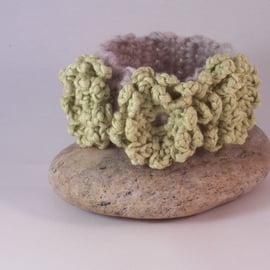 Crochet cuff with flower blossoms in soft lime