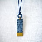 Long porcelain pendant with shapes connected with gold colour plated wire