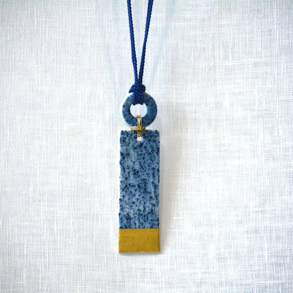 Long porcelain pendant with shapes connected with gold colour plated wire