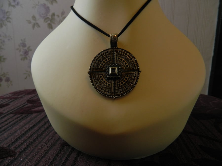 Pendant on black suede cord.  