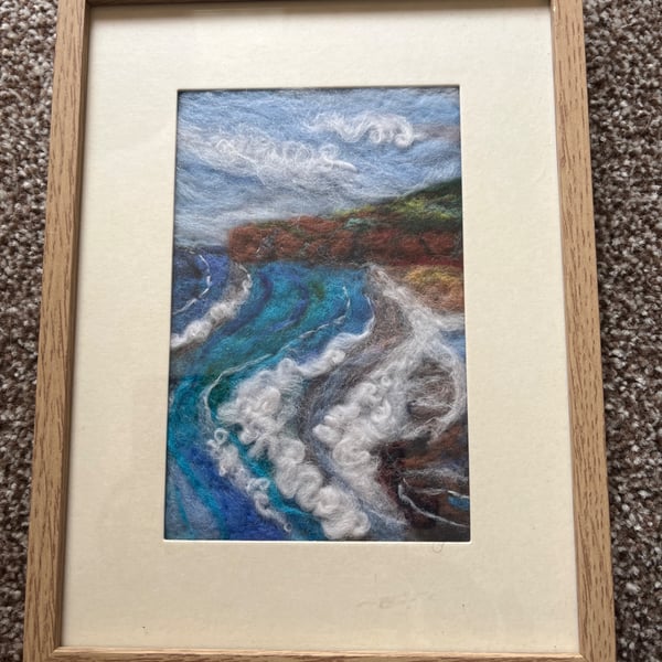 Needle felt coastal beach scene cliffs, waves, cloudy blue sky light wood frame 