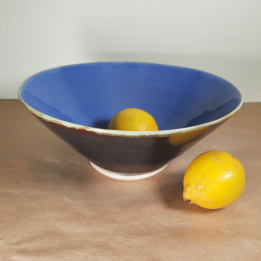 A wheel thrown lilac and dark brown stoneware bowl