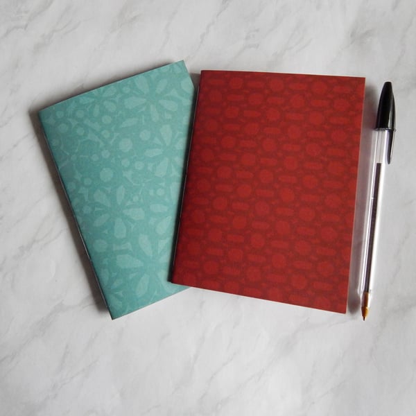 A6 Notebooks - Pair of Patterned 6x4 notebooks in red and aqua. 
